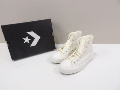 white converses with a black box and white converses on a white table
