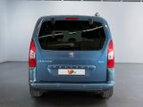the back end of a blue minivan parked in a garage