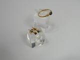 pair of gold and black crystal earrings on clear acrylic stand