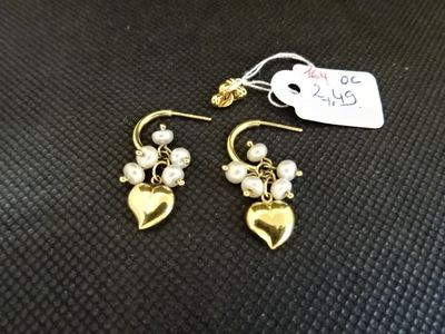 une paire de boucles d'oreilles ornées de perles et d'un cœur en or
