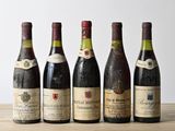 six bottles of wine are lined up on a wooden table