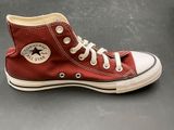 a close up of a pair of red converses on a table