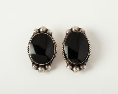 a pair of black onyx stone earrings on a white surface