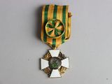 a gold medal with a green and white ribbon on it