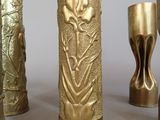 several gold vases are lined up in a row on a table