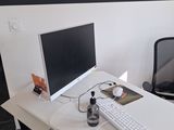 un bureau blanc sur lequel se trouvent un clavier et un écran