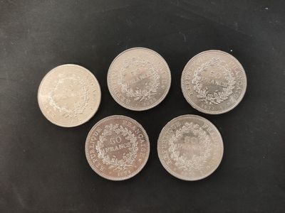 four silver coins sitting on top of each other on a table