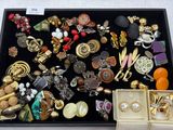 une boîte noire remplie de bijoux divers posée sur une table