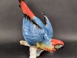 a figurine of a parrot sitting on a branch