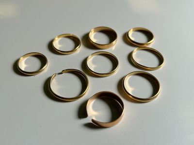 several gold rings are arranged in a circle on a white surface