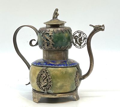 une théière en argent ornée d'un motif vert et bleu