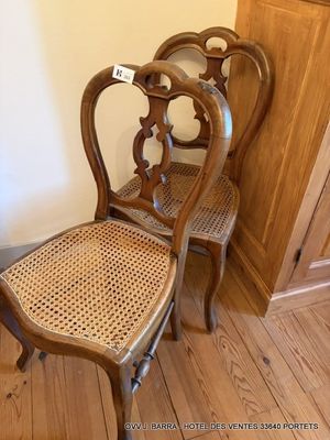 une paire de chaises anciennes françaises à dossier en rotin, dans un coin d'une pièce