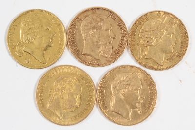 six souverains en or de tailles et de formes différentes sur une surface blanche