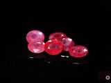 some very pretty pink gems on a black surface