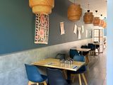 a table and chairs in a restaurant with a blue wall