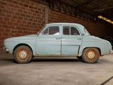 a old car parked in a garage with a brick wall behind it