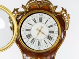 a clock that is sitting on a table with a mirror in front of it