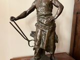 statue en bronze représentant une femme avec un fouet et un chien
