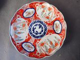 une assiette rouge ornée de motifs bleus et blancs