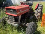 un tracteur rouge assis dans l'herbe
