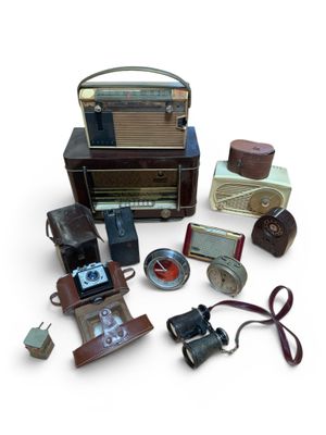 de nombreux appareils photo anciens et d'autres objets posés sur une surface blanche