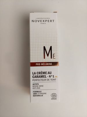 un gros plan d'une boîte de crème posée sur une surface blanche