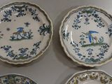 three plates with blue and white designs on them sitting on a table