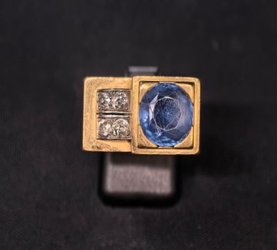 Gros plan sur une bague en or ornée d'un saphir bleu et de diamants