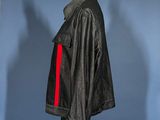 jacket on a mannequin stand with a shadow of a person in the background
