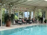 a swimming pool with chairs and tables in it