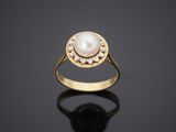 a gold ring with a pearl in the center