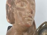 a statue of a woman with a clock on a table