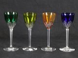 four different colored wine glasses are lined up in a row