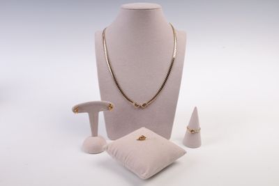 un mannequin blanc portant un collier, une bague et des boucles d'oreilles