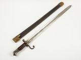 une vieille épée avec un manche en bois sur une surface blanche