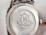 a close up of a wrist watch with a coin on it