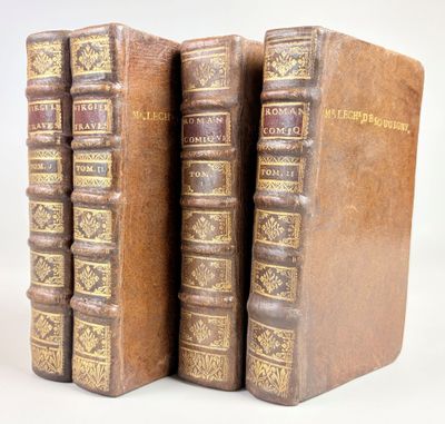 trois vieux livres posés l'un sur l'autre sur une surface blanche