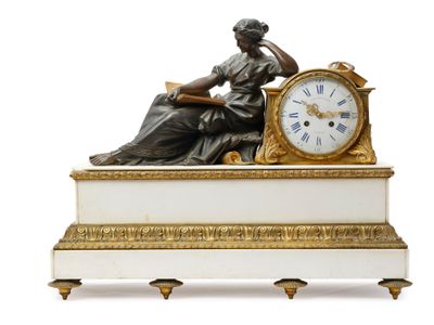 une statue de femme assise sur une table avec une horloge