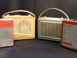 three old fashioned radio ' s are lined up on a black background