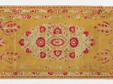 un tapis jaune et rouge orné d'un motif en médaillon