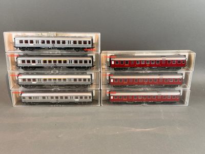 trois trains miniatures sont empilés les uns sur les autres sur une table