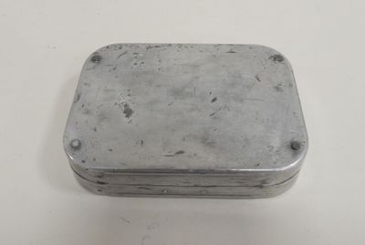 an old metal box sitting on top of a white table