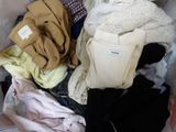 a pile of clothes sitting in a basket on the floor