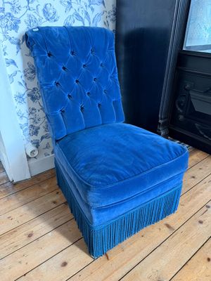 une image représentant une chaise bleue posée sur un parquet