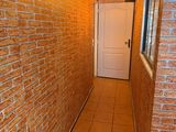 a hallway with a brick wall and a white door