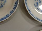 three blue and white plates are sitting on a table