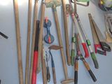 many different types of gardening tools hanging on the wall