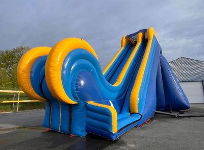 un toboggan aquatique gonflable bleu et jaune dans un parking