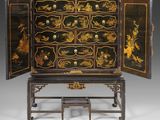 a black and gold decorated cabinet with drawers and drawers