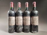 four bottles of wine are lined up in a row on a table